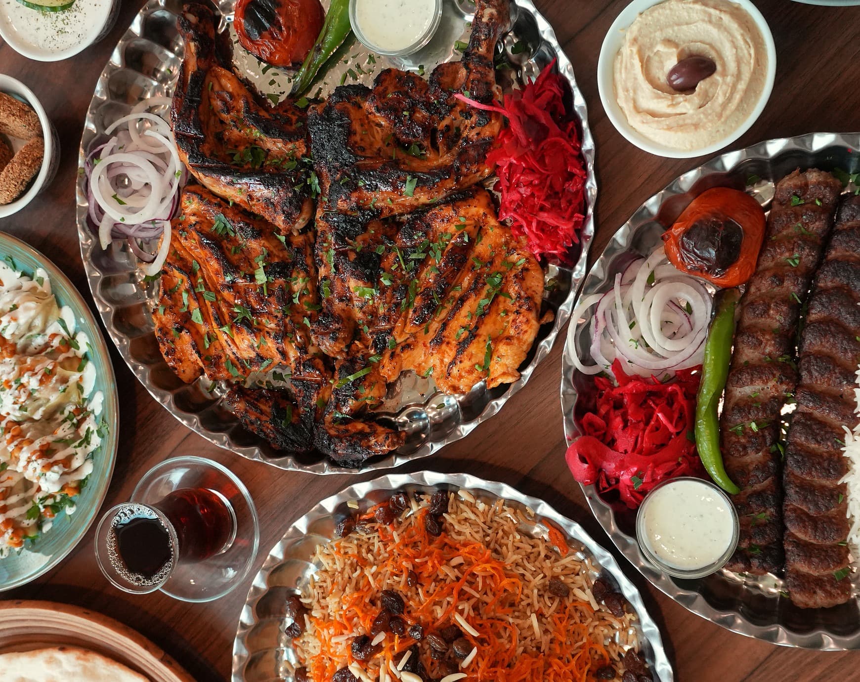 Grillplatten mit Jujeh, Kubideh, Safranreis und Kabuli Palau auf dem Tisch im Fereshteh